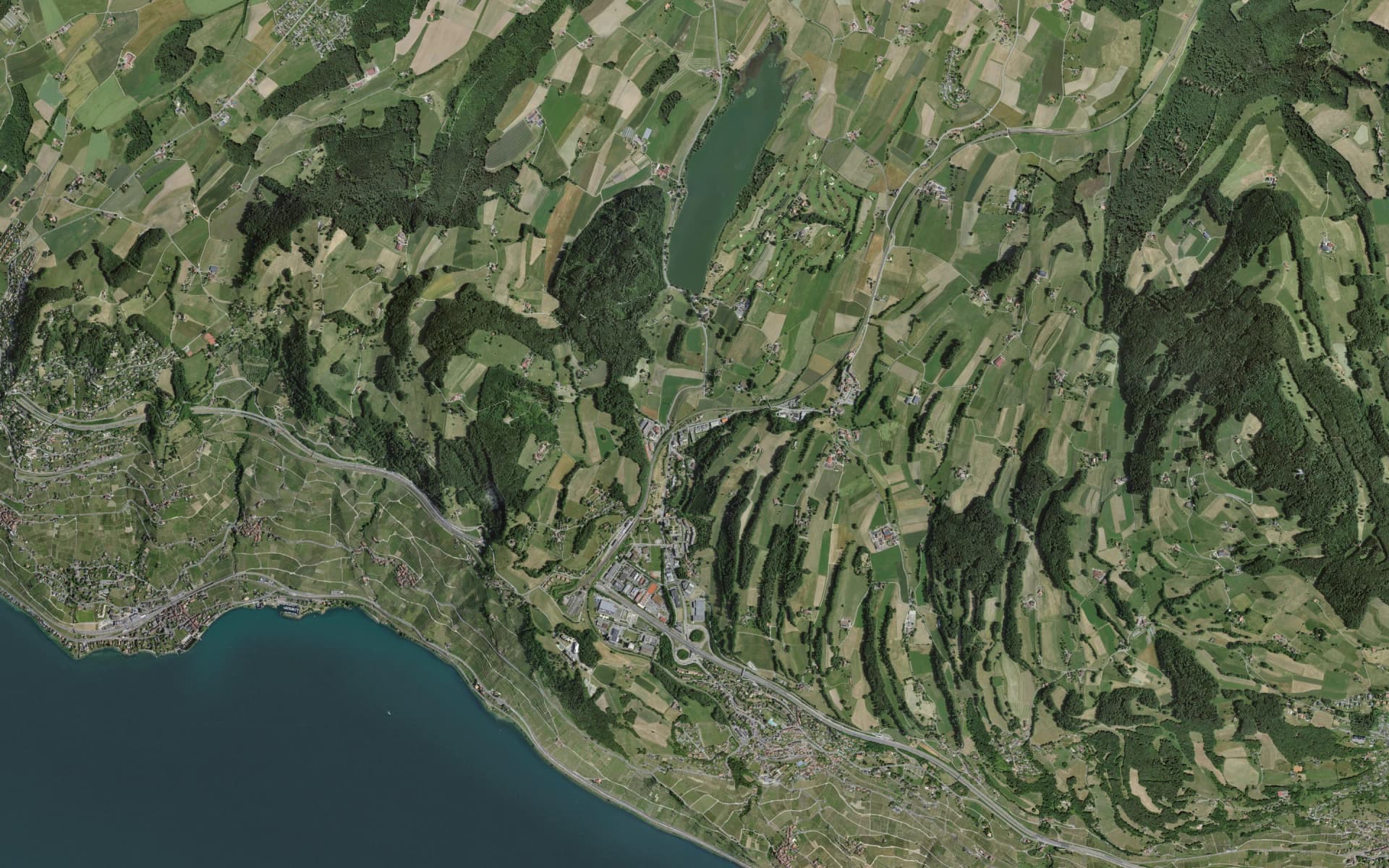 Vue aérienne verticale du Lac de Bret, de Puidoux, de la jonction autoroutière de Chexbres et des terrasses de Lavaux jusqu'au Léman ; l'A9, la sortie Chexbres et le trajet jusqu'à la maison sont tracés, un repère marque la maison