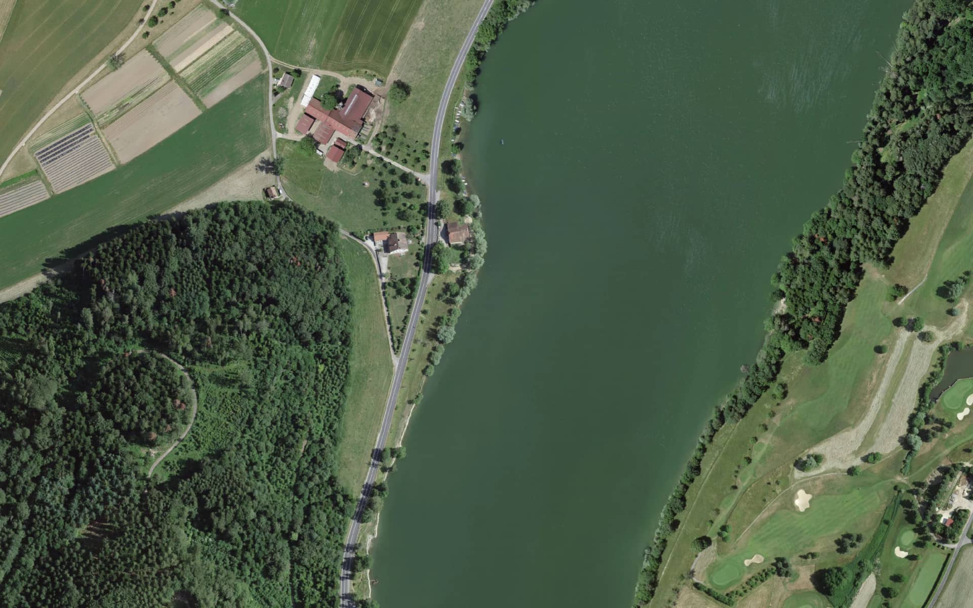 Vue aérienne verticale de la maison de maître de Puidoux, au bord de la route cantonale, face au Lac de Bret et à la colline boisée