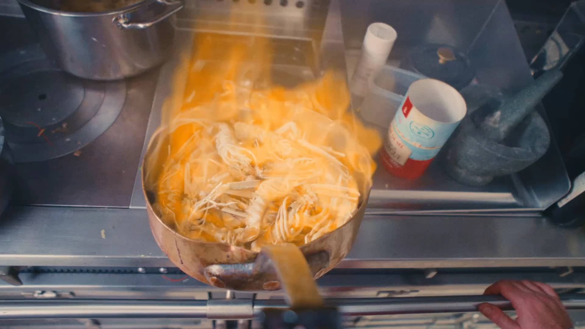 Andres Oppenheim flambe des langoustines dans une sauteuse en cuivre, dans la cuisine de la maison, à Puidoux