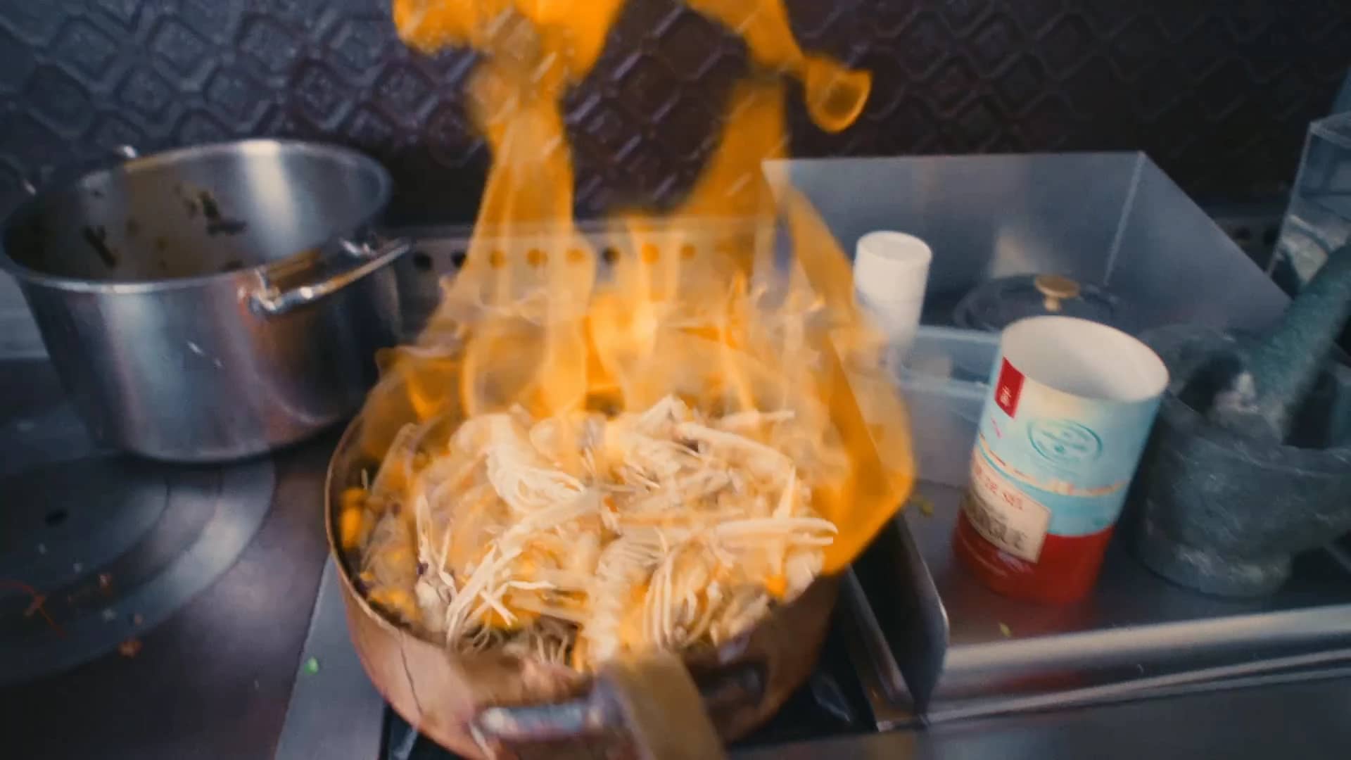 Flammes au-dessus des langoustines flambées par Andres Oppenheim, sur le fourneau de la cuisine de la maison, à Puidoux