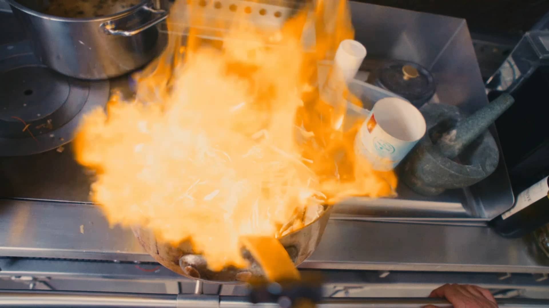 Une gerbe de flammes au-dessus de la sauteuse en cuivre : Andres Oppenheim flambe des langoustines sur le fourneau de la maison