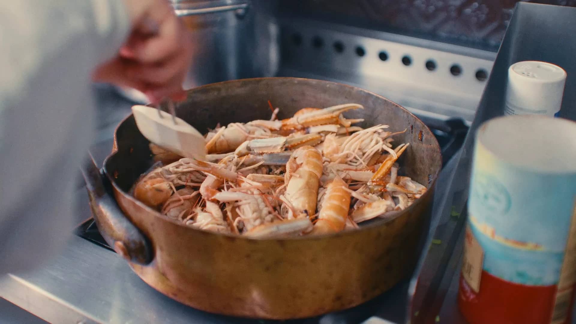 Des langoustines dans une sauteuse en cuivre, sur le fourneau de la cuisine de la maison