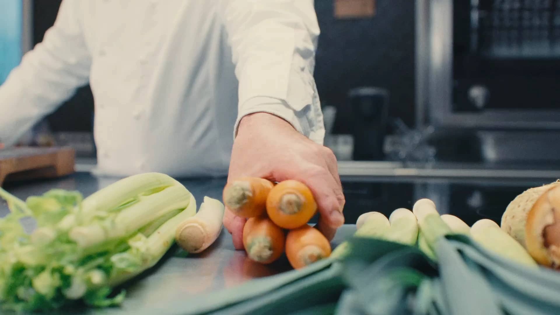 Andres Oppenheim dispose carottes, céleri et poireaux sur le plan de travail de la cuisine de la maison, à Puidoux