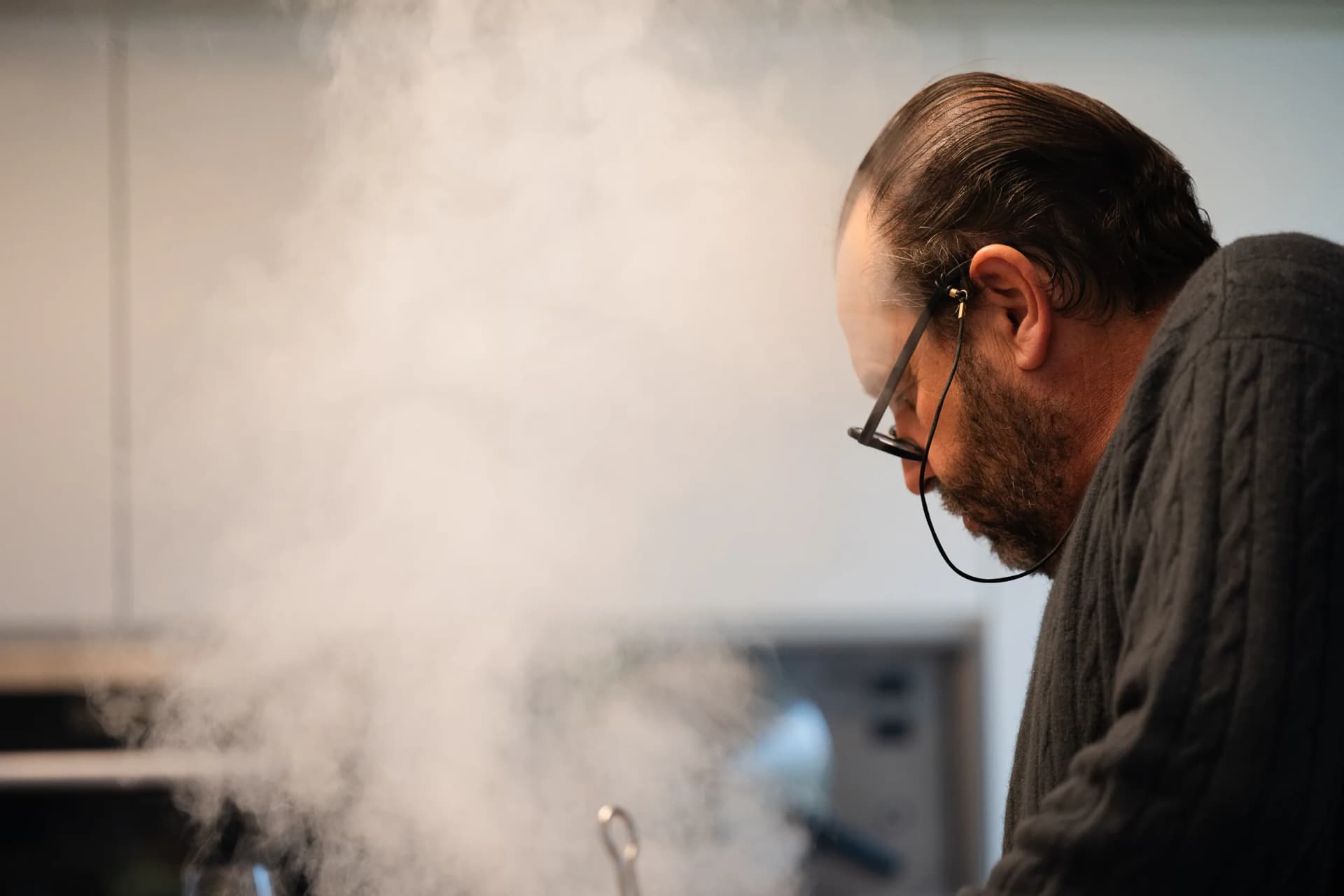 Andres Oppenheim, tête baissée, travaille dans la vapeur qui monte de la cuisine