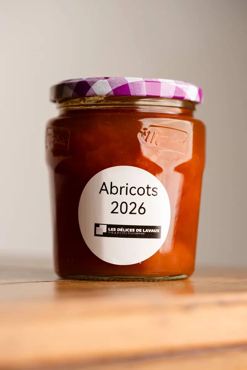 Un pot d'abricots 2026, étiquette ronde, sur une table en bois