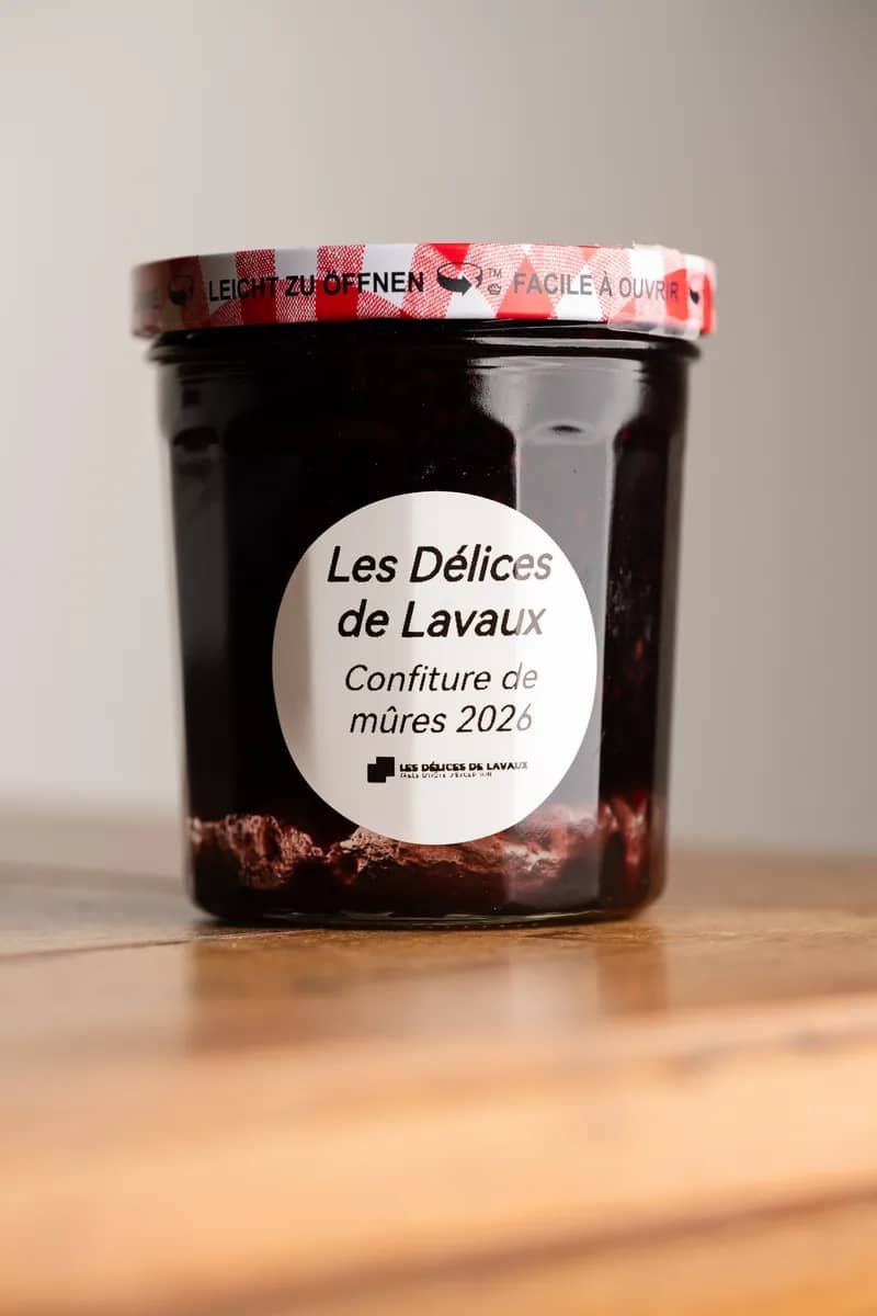 Un pot de confiture de mûres 2026, étiquette ronde, sur une table en bois