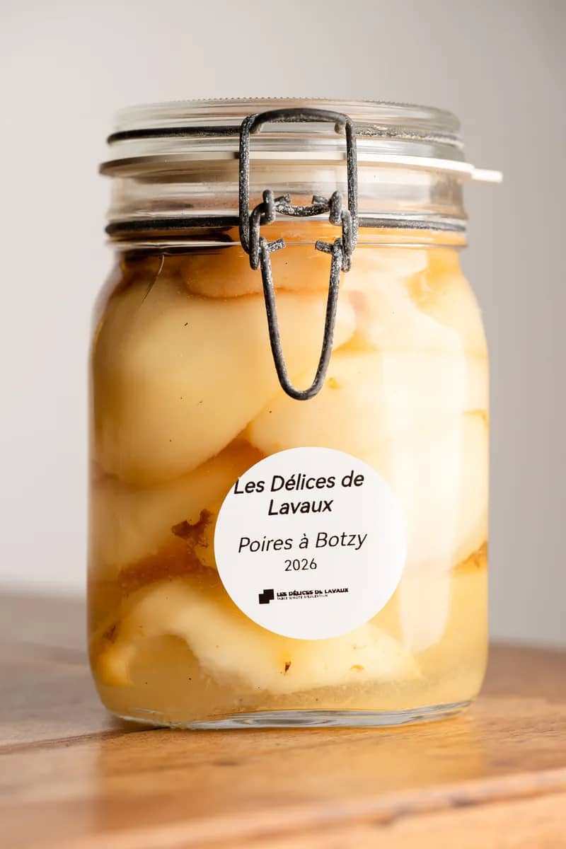 Un bocal de poires à Botzi au sirop, millésime 2026, étiquette ronde, sur une table en bois