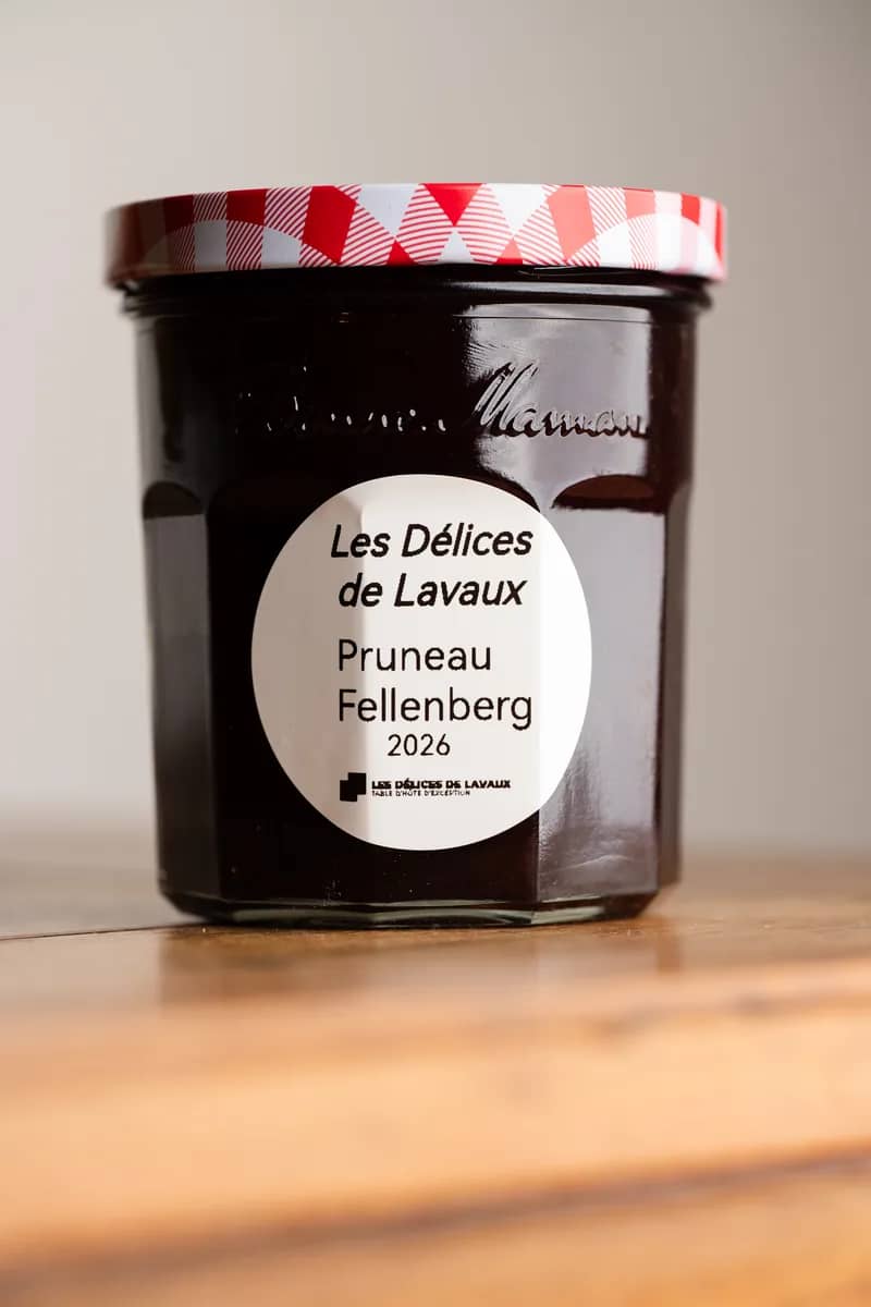 Un pot de pruneaux Fellenberg 2026, étiquette ronde, sur une table en bois