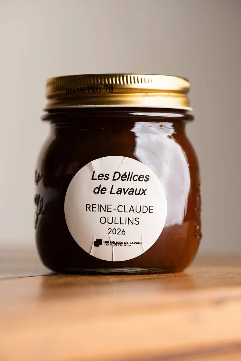 Un pot de reines-claudes d'Oullins 2026, étiquette ronde, sur une table en bois