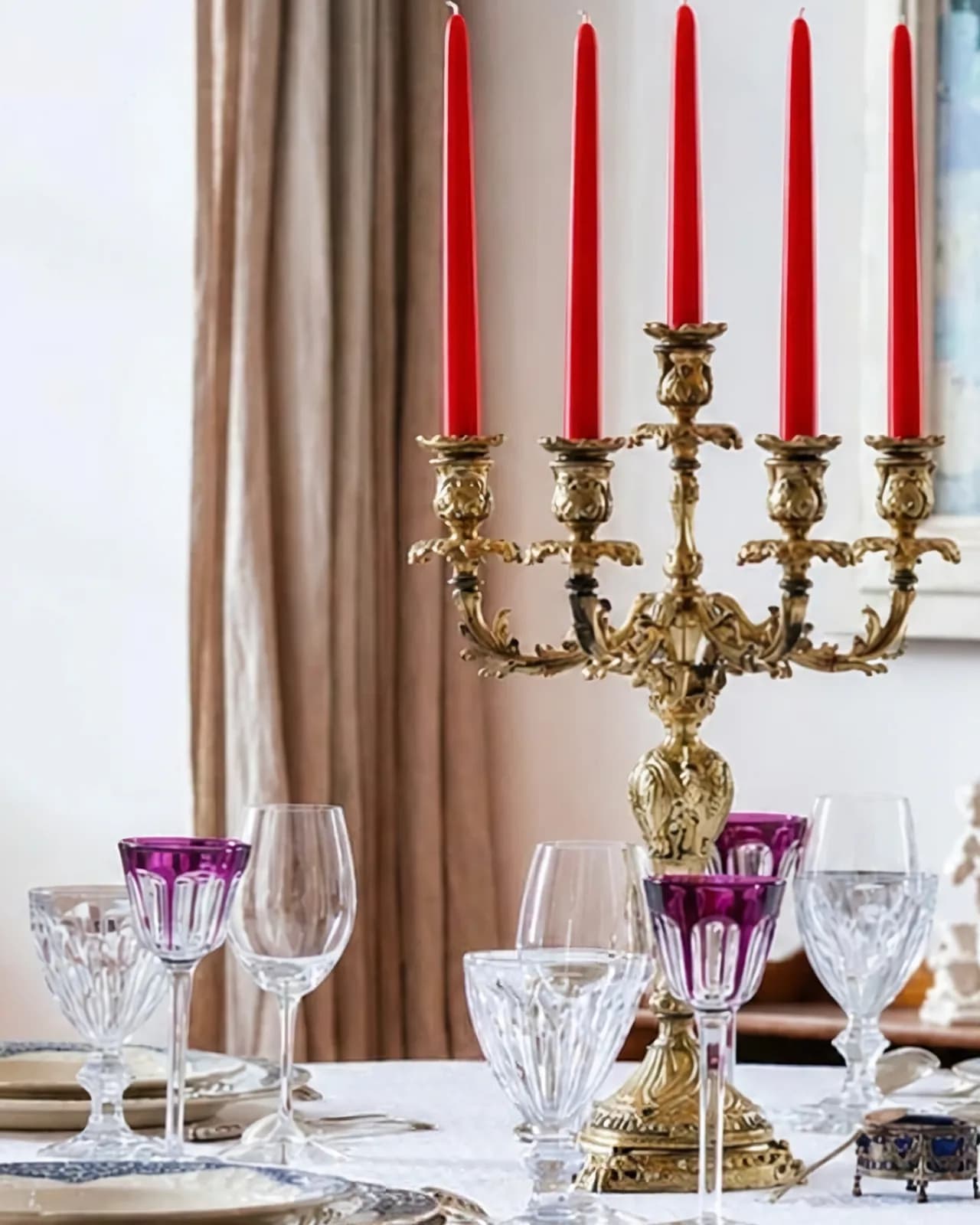 Le grand chandelier doré et les verres en cristal sur la table de la salle à manger, de la lumière du jour au soir, quand les bougies s'allument