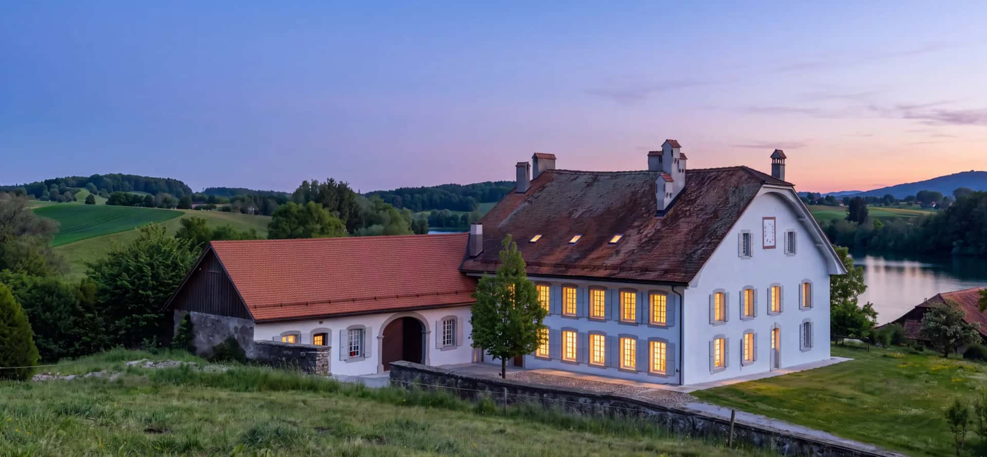 Le même jardin un soir d'été, à l'heure bleue, les fenêtres de la maison éclairées